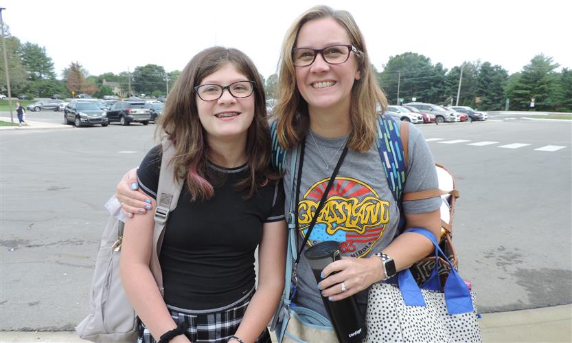 An adult and student smile